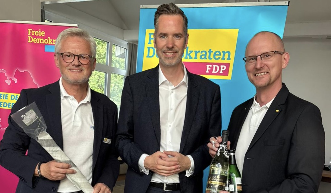 Daniel Farnung und Arne Wotrubez überreichen zum Dank einen Steinhuder Aal und eine Flasche Sekt der Neustädter Sektkellerei Dupres